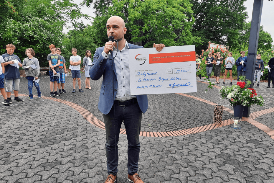 Schulleiter Dr. Michael Glaubitz mit dem symbolischen Scheck über die Förderung der ESS EKD.