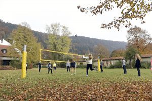 Schüler*innen beim Volleyballspielen an der frischen Luft.