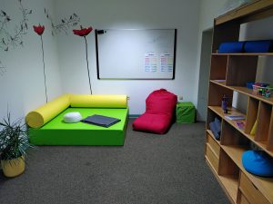 Klassenzimmerecke mit Schaumstoffsitzen, rotem Sitzsack, Tisch, Pflanze, Regal und Whiteboard. Bild: Paul-Gerhardt-Schule