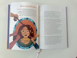 Aufgeschlagenes Buch mit dem Titel "Ester wird Königin" mit der Illustration einer gekrönten Frau und deutschem Text. Bild: ESS EKD/Janne Neumann